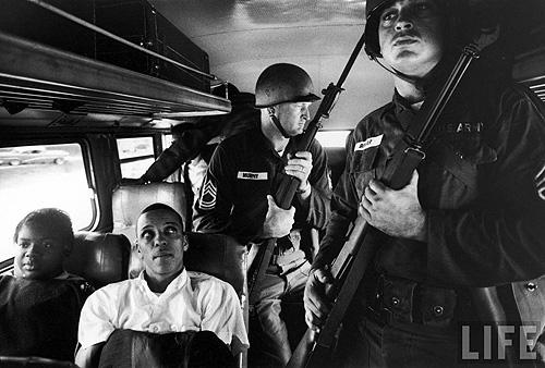 Photo: Freedom Riders Julia Aaron & David Dennis sitting on board interstate bus as they and 25 others are escorted by 2 National Guardsmen holding bayonets, on way from Montgomery, AL to Jackson, MS, May, 1961 - Photo by Paul Schutzer Gelatin Silver print #1335