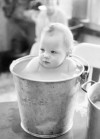 Baby Lindy Lou, 9 months old, enjoys her midday soak at Henton't Lodge, Alaska. 1959