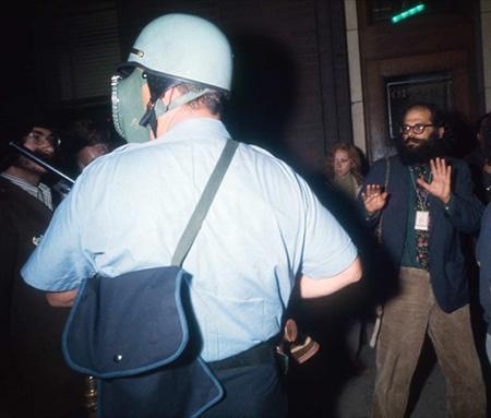 Poet Allen Ginsberg shown raising his hands in meek surrender to the police, Chicago Democratic Convention, 1968<br/>