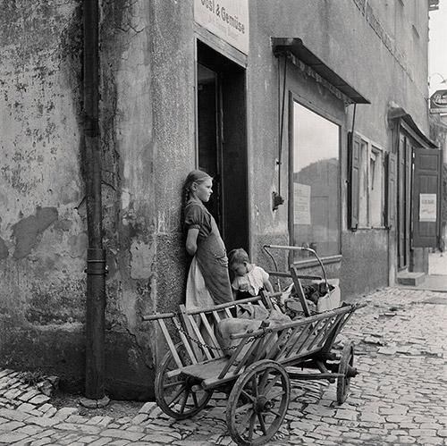 Waiting For Mom. TwoÂ children wait outsideÂ a grocery store with the family shopping cart, Hoescht, Germany, 1946.Â <br/>