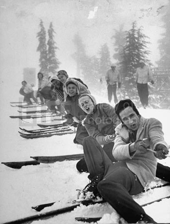 Playing tug-of-war during snowstorm at Timberline Lodge Ski Club party,1942 by Ralph Morse