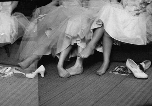 Girls resting their feet at first formal dance at the Naval Armory, 1956 Gelatin Silver print