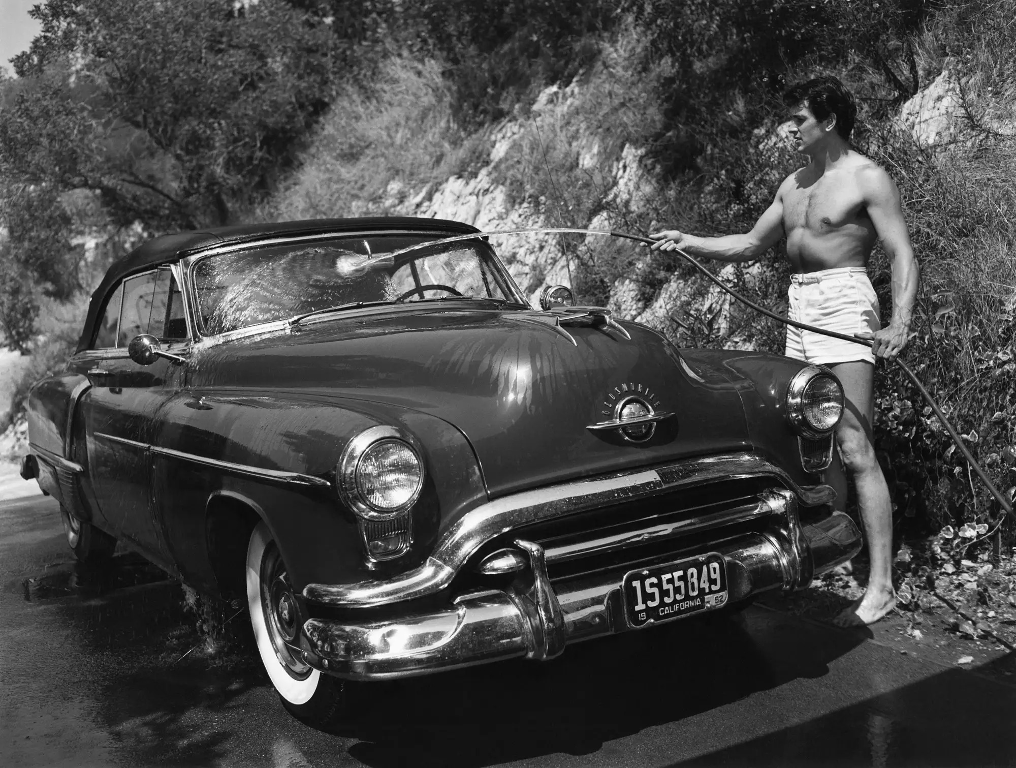 Rock Hudson washing his car, 1952