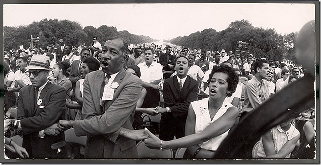 Francis Miller - Demonstrators hold hands and sing during Civil Rights demonstration in front of the Washington Monument, 1963