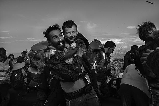 Kadoni Kinan, a volunteer and himself a refugee from Syria, pulled a young Syrian boy from a raft that had just arrived from Turkey Archival Pigment Print