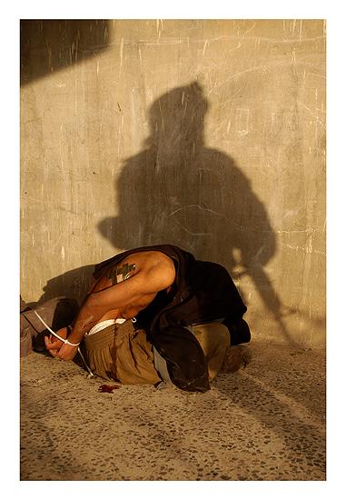 Marines from Bravo company, 1st Battalion, 8th Marine Regiment detain an insurgent after they shot him and his two comrades in the neighborhood nicknamed "Queens" during the battle for Fallujah, Iraq on November 13, 2004. Archival Pigment Print