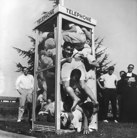 Joe Munroe; Twenty-two exuberant St. Mary's College students folded and stacked inside an on campus phone booth in an attempt to set a record for phone booth cramming, Moraga, California, March 26, 1959
