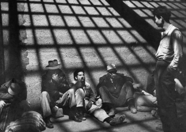 A group of illegal Mexican immigrants sprawled on floor of border patrol jail cell await deportation back to their homeland during "Operation Wetback", 1955