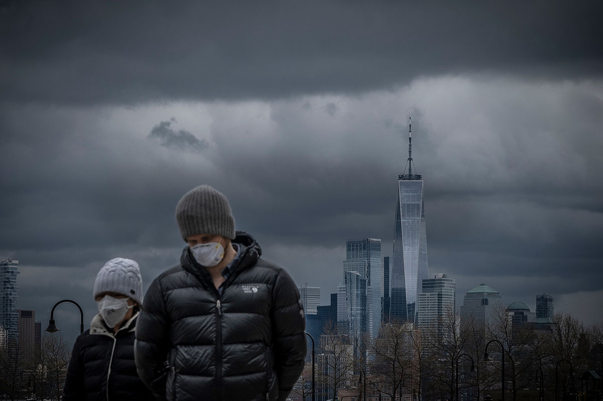 April 18, 2020: With the skyline of lower Manhattan in the background, a couple strolls the boardwalk in Hoboken, NJ during the Covid Pandemic
