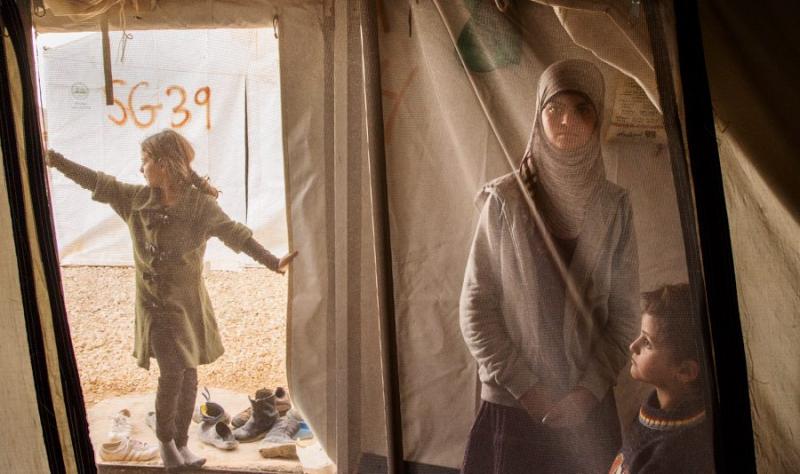 A young girls spends time with her her siblings in her family tent at the Al Za’atri refugee camp near Mafraq, Jordan, 2013. With nearly 200,000 people, Al Za’atri is now the second largest refugee camp in the world.<br/>Please contact Gallery for price
