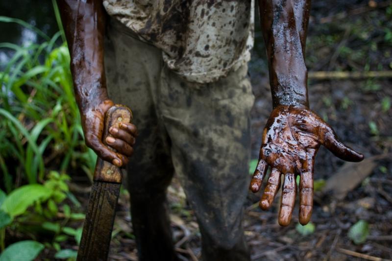 A worker subcontracted by Shell Oil Company cleans up an oil spill from a well owned by Shell that had been left abandoned for over 25 years, 2004<br/>Please contact Gallery for price