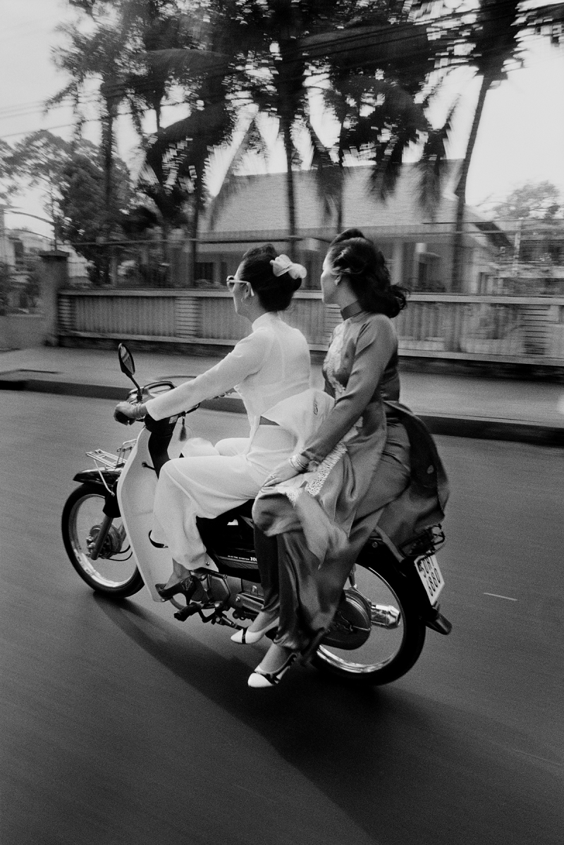 Photo: Except for the motorbike, these traditionally dressed women could be from another era of Saigon’s stylish past. Vietnam, 1994 Archival Pigment Print #2603
