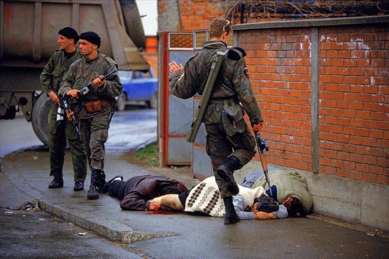 Photo: Members of Arkan's Serbian paramilitary group, the Tigers, execute unarmed Muslim civilians  during the first battle of the Bosnian war. This image was used as evidence in numerous  procedures to indict and convict people of war crimes. Bilijenia, Bosnia  Archival Pigment Print #2949