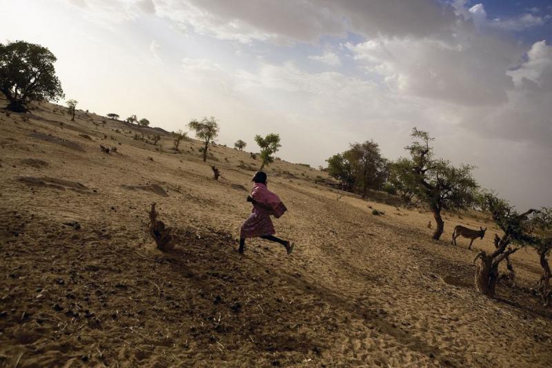 Photo: A Darfuri girl runs in a camp for the displaced during the genocide. Darfur, Sudan 2005 Archival Pigment Print #2956