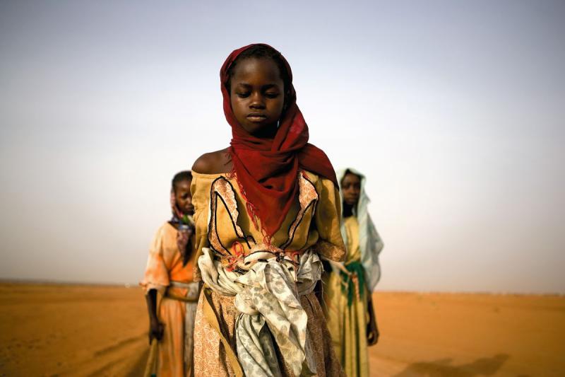Photo: Young displaced girls from Darfur, Sudan leave a camp to gather firewood for their families. The  US government declared the war in Darfur a genocide. Darfur, Sudan 2005 Archival Pigment Print #2957