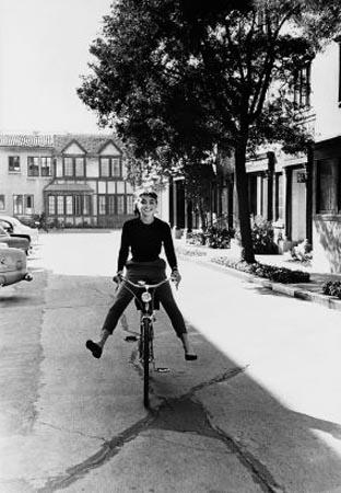 Audrey Hepburn rides a bike from the makeup department to the set of Pigment Print