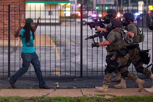 Rashaad Davis, 23, backs away as St. Louis County police officers approach him with guns drawn and eventually arrest him, Ferguson, Missouri, August 11, 2014